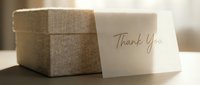 Elegant linen gift box with a handwritten Thank You card in warm golden light, perfect for gratitude, celebrations, and special occasions.