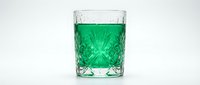 Vibrant green beverage in crystal glass with decorative pattern, isolated on white background for beverage, drink, and refreshment design projects.