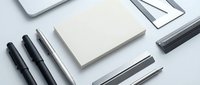 Minimalist office supplies flat lay with blank notepad, black pens, pencils and paper sheets on white background for branding and stationery design projects.