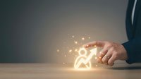 Person icon glowing with warm light particles emerging from hand of professional in business attire, symbolizing innovation, success, and human potential for corporate and technology concepts.