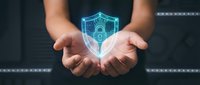 Hands holding glowing digital shield with lock icon, representing cybersecurity, data protection, and secure technology solutions for business and network safety.