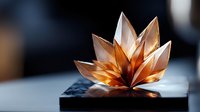 Delicate copper-toned lotus flower sculpture with metallic petals catching light and creating dramatic shadows on dark surface, artistic macro photography.
