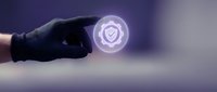 Hand in black glove touching glowing security shield icon with checkmark symbol representing cybersecurity protection and digital safety verification.