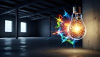 Glowing light bulb with colorful energy explosion in modern industrial loft space representing creative innovation and breakthrough ideas for business concepts.