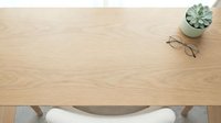 Minimalist workspace with succulent plant, eyeglasses, and curved desk drawer on light wood surface, suitable for office and lifestyle design projects.