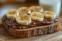 Chocolate spread on whole grain bread topped with fresh banana slices and chia seeds for healthy breakfast or snack on wooden cutting board.