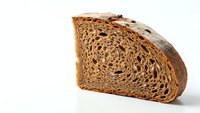 Fresh sliced rye bread with seeds showing detailed texture and airy crumb structure on white background for culinary and food photography projects.