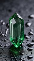 Emerald green crystal point standing on wet dark surface with water droplets creating mystical atmosphere for healing and meditation practices.
