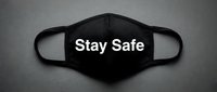 Black fabric face mask with Stay Safe text on gray background, health protection concept in monochrome style for awareness campaigns.