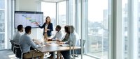Professional businesswoman presenting financial data to diverse team in modern conference room with city skyline view during corporate meeting.