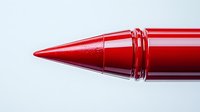 Close-up of shiny red ballpoint pen tip against white background, showcasing precise writing instrument detail for business and education concepts.