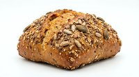 Artisan multigrain bread loaf with sunflower seeds and mixed grains on white background. Healthy whole wheat bakery product for breakfast and meals.