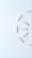 White oval pharmaceutical tablets and capsules arranged on light background, suitable for healthcare, medicine, and wellness industry applications.
