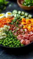 Fresh colorful protein bowl with diced ham, boiled eggs, green peas, cucumber, carrots, potatoes and herbs arranged in rows on dark plate. Healthy meal prep concept.
