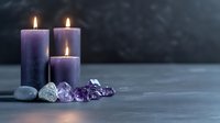 Purple lit candles with amethyst crystals and zen stones on dark background creating peaceful atmosphere for meditation, spa treatments and spiritual practices.