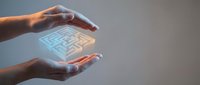 Hands holding glowing digital maze hologram, representing problem solving, innovation, and technology solutions for business and corporate applications.