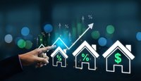 Real estate investment growth concept with hand pointing at rising house icons showing percentage and dollar symbols on dark blue bokeh background.