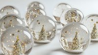 Miniature snow globes with golden Christmas trees and stars create magical holiday decoration display on white background for festive seasonal design.