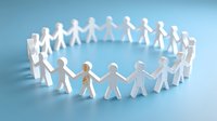 White paper cutout figures holding hands in circle formation on blue background, symbolizing unity, teamwork, and community support.