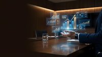 Modern businessman in dark suit analyzing financial data on holographic display at wooden desk with glass of water, laptop, and glowing charts in contemporary office environment.