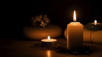 Relaxing spa atmosphere with burning candles creating warm ambient lighting on wooden surface for wellness and meditation practices.