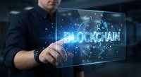 Businessman touching futuristic holographic blockchain interface with glowing network connections and digital particles in modern office environment.