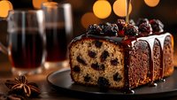 Chocolate glazed pound cake with cherries and dark chocolate ganache topping, decorated with fresh berries on dark background with festive bokeh lights.