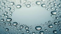 Water droplets on smooth surface creating natural pattern with crystal clear transparency and refreshing moisture texture for wellness concepts.
