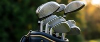 Golf clubs in bag at sunset with warm golden light creating atmospheric sports equipment scene for recreational activity and leisure lifestyle.
