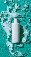 White pump bottle with water droplets on turquoise ocean wave background with white foam, ideal for skincare, cosmetics, beauty product marketing and spa wellness branding.