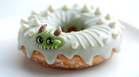 Playful green monster donut with white frosting and decorative horns, featuring cute cartoon face and cream dots on top, fresh baked pastry on white surface.