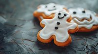 Festive gingerbread cookies with white icing and smiling faces on rustic wooden surface for holiday baking and Christmas celebration themes.