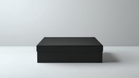 Minimalist black rectangular box with lid on white surface against gray background, casting subtle shadow. Clean modern packaging design for luxury products.