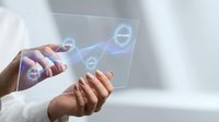 Businessman using transparent tablet with holographic interface displaying connected network nodes for digital technology and business innovation concepts.