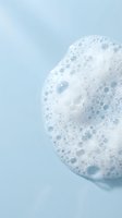 Spherical foam bubble with white suds and craters against soft blue background, isolated on clean surface for skincare, cosmetics, and wellness product packaging design.