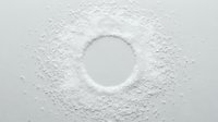 White powder scattered on surface with circular empty space in center, suitable for cosmetics, baking, cleaning products, and design mockups.