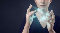 Young Caucasian businesswoman manipulating holographic geometric shapes with hands against dark background for futuristic technology concepts.