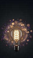 Glowing vintage Edison light bulb with magical golden sparkles and bokeh effects on dark background for creative design projects.