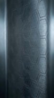 Close-up of tire tread pattern showing hexagonal grooves and textured rubber surface for automotive and transportation design projects.