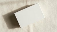 Blank white business card mockup on textured beige fabric background with natural shadow overlay for branding and corporate identity design projects.