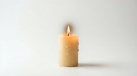 Single burning candle with warm flame against clean white background creating peaceful ambiance for meditation, relaxation and home decor concepts.