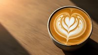 Coffee cup with heart latte art on wooden table. Cappuccino with milk foam design. Morning beverage for cafe menu, coffee shop branding and hospitality.