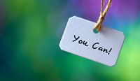 White paper tag with motivational message You Can hanging on string against blurred colorful bokeh background for inspiration and encouragement concepts.