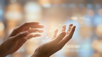 Hands releasing glowing light particles in warm sunlight, symbolizing hope, healing, spirituality, and positive energy transfer between people.