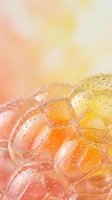 Abstract soap bubbles with water droplets in warm orange and yellow gradient background for wellness and relaxation concepts.
