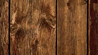 Rustic weathered wooden planks with natural grain patterns and knots creating warm brown textured surface for backgrounds and design projects.