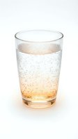 Glass of sparkling apple juice or cider with carbonated bubbles, isolated on white background for beverage, drink, and refreshment design projects.