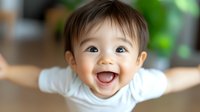 Joyful Asian toddler with bright smile and expressive eyes wearing white t-shirt, laughing and showing pure happiness against blurred background. Perfect for wellness and family themes.