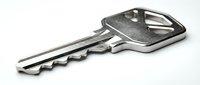 Single metallic key isolated on white background, ready for design use in security, access, and lock-related projects.
