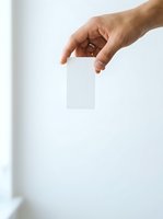 Male hand holding blank white card against neutral background for branding, marketing, and business presentation mockups.
